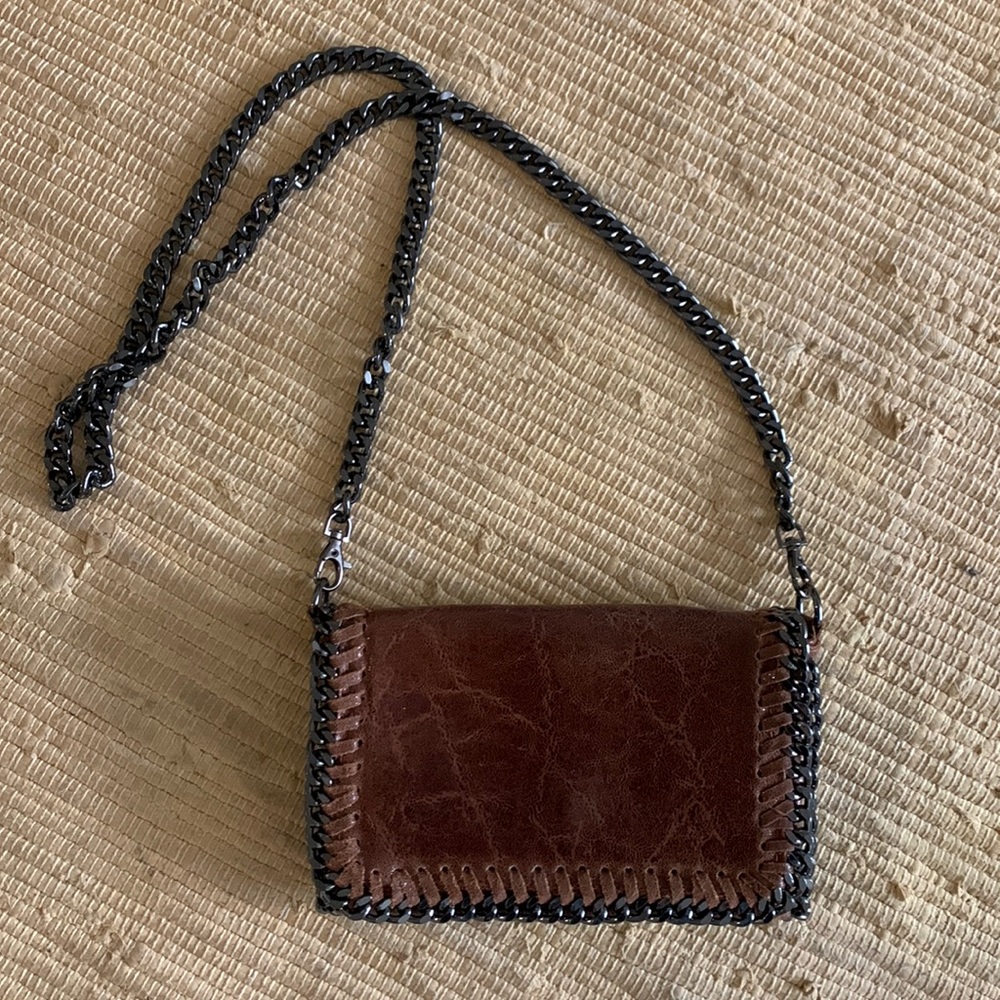 Brown leather crossbody clutch bag with gunmetal chain strap